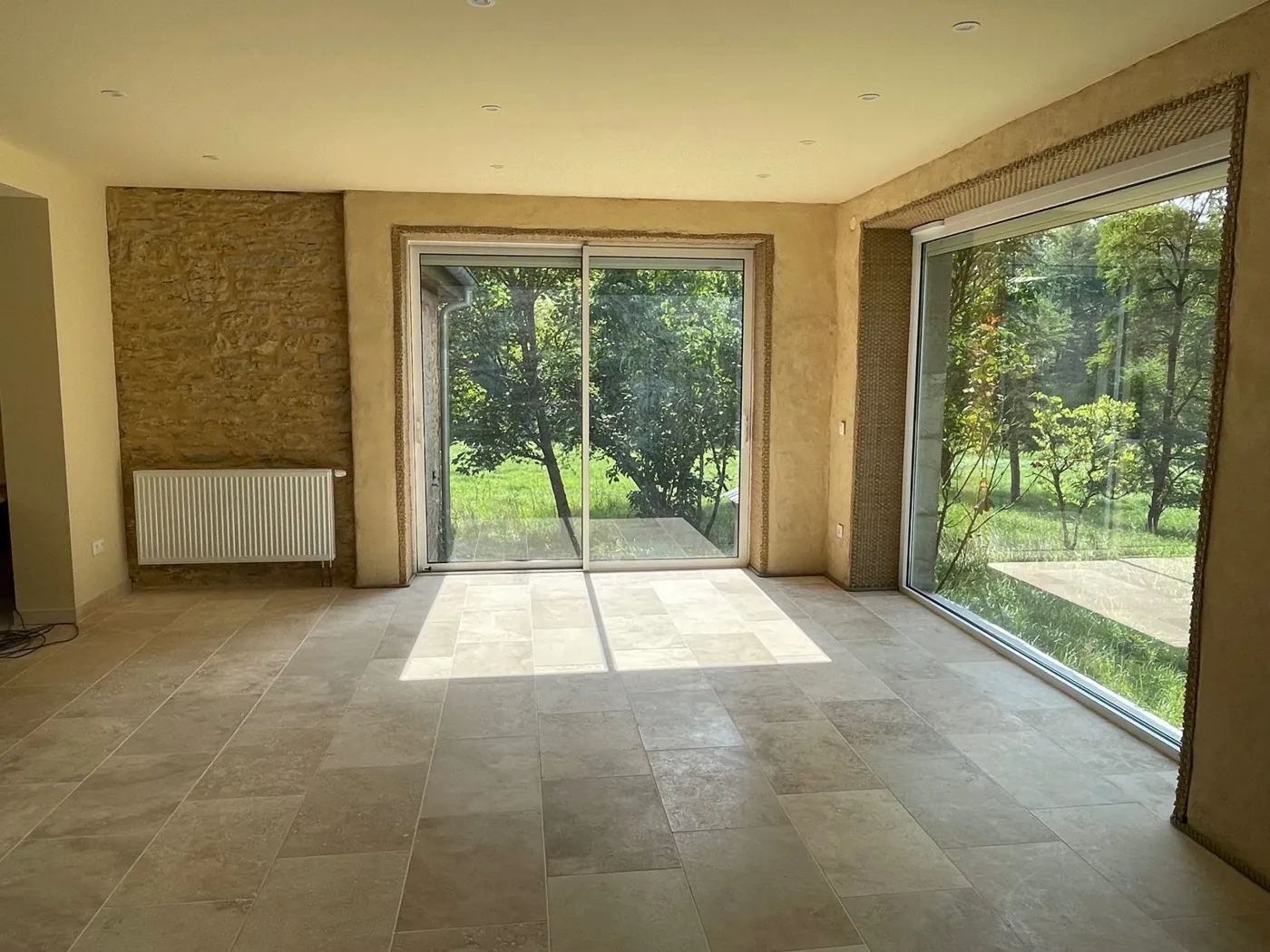 Séjour rénové avec mur en pierre apparente, maison forestière de 1870
