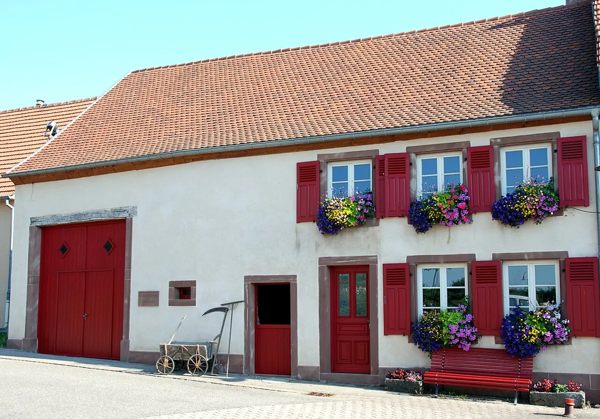 Maison lorraine traditionnelle à Rouhling, façade enduite et porte de grange